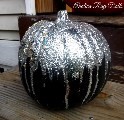 adding glitter to a pumpkin for halloween